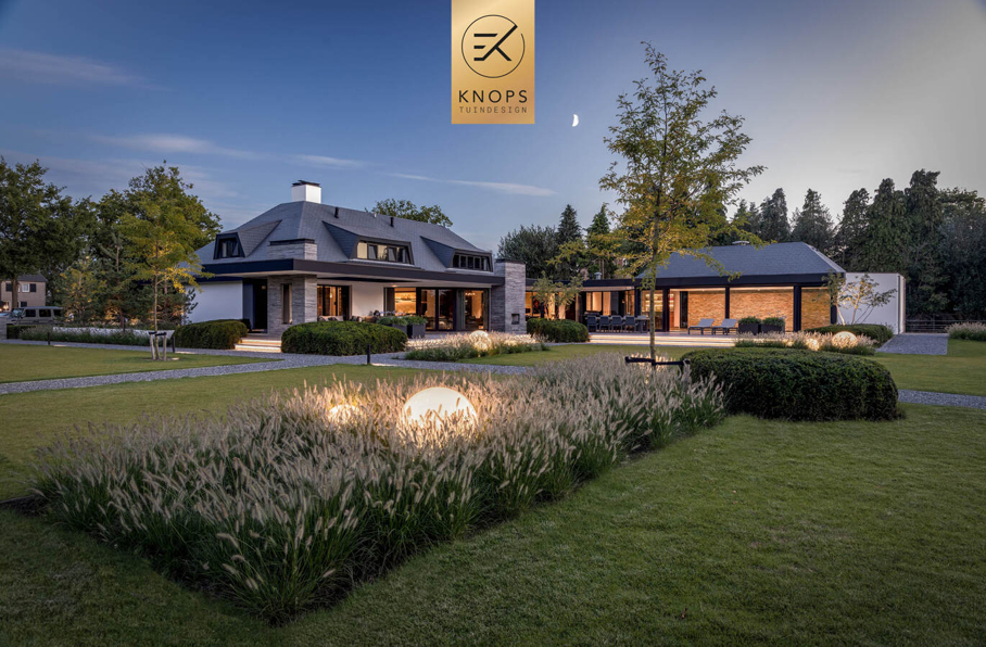  sfeertuinen zwembad meerstammige bomen tuin verlichting avond witte polyester bakken knops tuindesign tuinarchitect overkapping wellness luxe buitenhaard vlonder